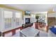 Bright living room featuring a fireplace, hardwood floors, and access to the patio at 3302 E Maritana Dr, St Pete Beach, FL 33706
