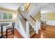 A staircase with wooden handrails that sits between the living room and the dining area at 3302 E Maritana Dr, St Pete Beach, FL 33706