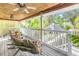 Spacious covered porch with rocking chairs, ceiling fans, and tranquil garden views at 3302 E Maritana Dr, St Pete Beach, FL 33706