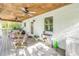 Bright covered porch with rocking chairs, ceiling fans and access to the house at 3302 E Maritana Dr, St Pete Beach, FL 33706