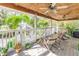 Relaxing covered porch with rocking chairs, ceiling fans, and view of a gazebo at 3302 E Maritana Dr, St Pete Beach, FL 33706