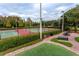 Well-maintained tennis courts with seating areas and landscaping at 3454 Hillmoor Dr, Palm Harbor, FL 34685