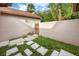 The backyard features stone pavers, a privacy wall, and a wooden gate leading to additional yard space at 3454 Hillmoor Dr, Palm Harbor, FL 34685