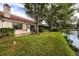 Scenic backyard featuring lush green grass, mature trees, and serene waterfront views at 3454 Hillmoor Dr, Palm Harbor, FL 34685