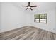 A modern bedroom with wood flooring, a ceiling fan, and a bright window at 3454 Hillmoor Dr, Palm Harbor, FL 34685