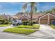 Well-maintained townhome featuring a manicured lawn, mature palm tree, and attached garage at 3454 Hillmoor Dr, Palm Harbor, FL 34685