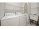 Functional laundry area equipped with a washing machine, dryer, shelves, and a utility sink at 3454 Hillmoor Dr, Palm Harbor, FL 34685