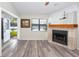 Bright living room featuring wood flooring, a fireplace, and a picturesque view of the lake at 3454 Hillmoor Dr, Palm Harbor, FL 34685