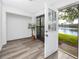 Enclosed patio features wood flooring and a view of the outdoor lake from the open door at 3454 Hillmoor Dr, Palm Harbor, FL 34685