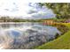 Beautiful wide view of pond featuring community buildings surrounded by trees at 3454 Hillmoor Dr, Palm Harbor, FL 34685