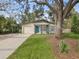 Updated home with teal door, carport, and mature oak tree at 404 3Rd Ne Ave, Largo, FL 33770