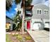 Inviting townhouse with a red front door, balcony, and lush landscaping at 411 S Fremont Ave # B, Tampa, FL 33606