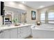 Bright bathroom featuring a soaking tub, double vanity, and shower, with a view to the main bedroom at 411 S Fremont Ave # B, Tampa, FL 33606