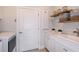Bright laundry room with white cabinets and shelving at 4259 Goldfoil Rd, Spring Hill, FL 34609