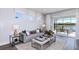 Living room with gray sofa and sliding glass doors to patio at 4259 Goldfoil Rd, Spring Hill, FL 34609