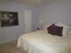 Spacious bedroom with king-size bed and large picture at 6000 20Th N St # 129, St Petersburg, FL 33714