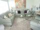 Living room with light green leather sofas, coffee table, and large artwork at 6000 20Th N St # 129, St Petersburg, FL 33714