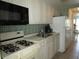 White kitchen with gas stove and refrigerator at 6000 20Th N St # 129, St Petersburg, FL 33714