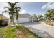 Single-story home with a large driveway and tropical landscaping at 7872 1St S Ave, St Petersburg, FL 33707