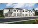 Exterior view of a row of townhouses with gray siding and green garage doors at 1566 Hammer Pl, Clearwater, FL 33756