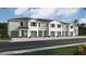 Exterior view of a row of townhouses with gray siding and green garage doors at 1566 Hammer Pl, Largo, FL 33774