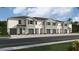 Exterior view of a row of townhouses with gray siding and green garage doors at 1566 Hammer Pl, Clearwater, FL 33756