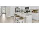 White kitchen with marble countertops and stainless steel appliances at 1574 Hammer Pl, Largo, FL 33774