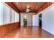 Bright sunroom with wood walls and floors, and access to a bathroom at 33137 Cercelia Rd, Dade City, FL 33523