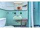 Bathroom with teal tile, shower and pedestal sink at 33137 Cercelia Rd, Dade City, FL 33523