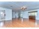 Living room with wood floors, ceiling fan, and view into kitchen at 33137 Cercelia Rd, Dade City, FL 33523