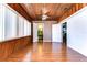Bright sunroom with wood walls and floors, and access to a bathroom at 33137 Cercelia Rd, Dade City, FL 33523