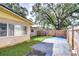 Back exterior view of the house, showing a large tree and fenced backyard at 33137 Cercelia Rd, Dade City, FL 33523