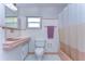 Retro bathroom with pink tile, vanity, and tub at 33137 Cercelia Rd, Dade City, FL 33523