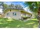 Tan block home with a landscaped yard and palm tree at 33137 Cercelia Rd, Dade City, FL 33523