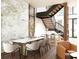 Modern dining room featuring a marble accent wall, long table with seating, and a staircase in the background at 4441 Pompano Se Dr, St Petersburg, FL 33705