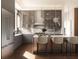 Modern kitchen with gray cabinets, marble counters, island with seating, and glass-front upper cabinets at 4441 Pompano Se Dr, St Petersburg, FL 33705