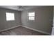 Well-lit bedroom with two windows, wood-look floors, and ceiling fan at 4614 Webster St, Tampa, FL 33610