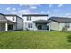 Large grassy backyard with a covered patio on a sunny day at 10316 Cross River Trl, Parrish, FL 34219