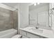 Bathroom featuring a shower-tub combo with tiled walls, a white vanity, and ample lighting at 10316 Cross River Trl, Parrish, FL 34219
