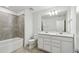 Modern bathroom with double vanity, large mirror, and shower-tub combo at 10316 Cross River Trl, Parrish, FL 34219