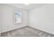Bright bedroom features gray carpet, a window with blinds, and neutral walls at 10316 Cross River Trl, Parrish, FL 34219
