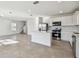 Open-concept kitchen featuring stainless steel appliances, a center island, and ample cabinet space at 10316 Cross River Trl, Parrish, FL 34219