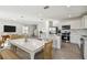 Open-concept living room and kitchen with a dining table and modern appliances, creating a bright and inviting space at 10316 Cross River Trl, Parrish, FL 34219