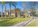 House exterior with a three-car garage and lush landscaping at 16183 Colchester Palms Dr, Tampa, FL 33647