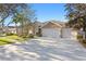 Landscaped front yard with a three-car garage at 16183 Colchester Palms Dr, Tampa, FL 33647