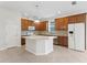 Open kitchen with wood cabinets, an island, and tile flooring at 16183 Colchester Palms Dr, Tampa, FL 33647