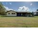 View of the home's back, showcasing the screened patio and yard at 18138 Lake Worth Blvd, Port Charlotte, FL 33948