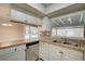White kitchen cabinets, granite counters, and a view into the dining area at 18138 Lake Worth Blvd, Port Charlotte, FL 33948