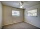 Bright bedroom with neutral walls, carpeted floor, and two windows at 18138 Lake Worth Blvd, Port Charlotte, FL 33948