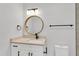 Updated bathroom with white vanity, round mirror, and modern fixtures at 2623 W Tyson Ave, Tampa, FL 33611